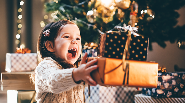 Lovely little girl receiving a Christmas gift.